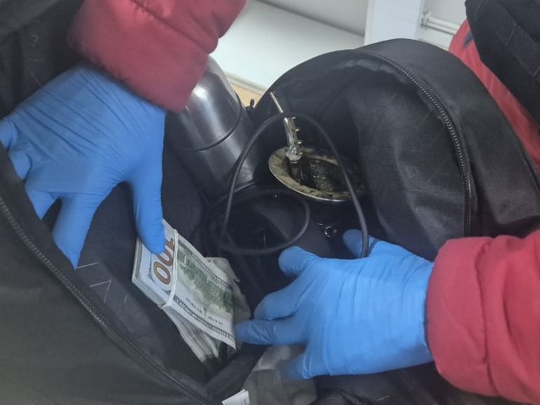 El dinero en efectivo estaba oculto debajo del asiento trasero del auto. 